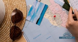 Featured image for the Healthy Travel tips blog post of a map with a printed photo on top as well as a sun hat and some sunglasses.